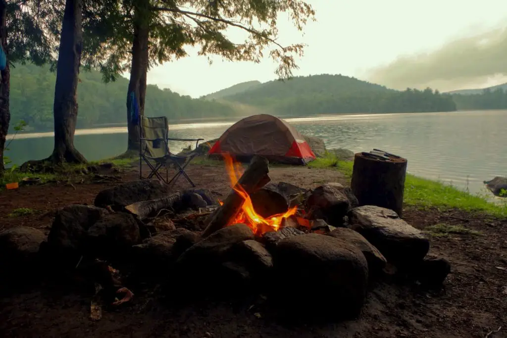 Primitive campsite at the lakeshore, firepit and a travel seat to relax in by the fire.