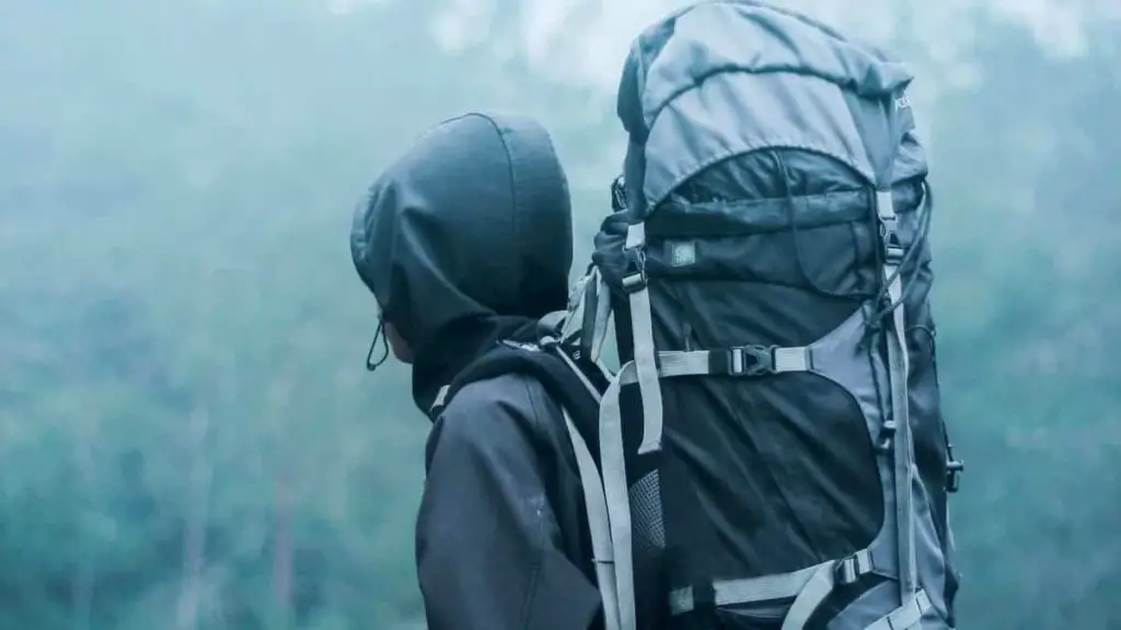 Hiking in the wet and rainy weather in the forest with pack exposed and not covered - How to Buy the Right Hiking Backpack