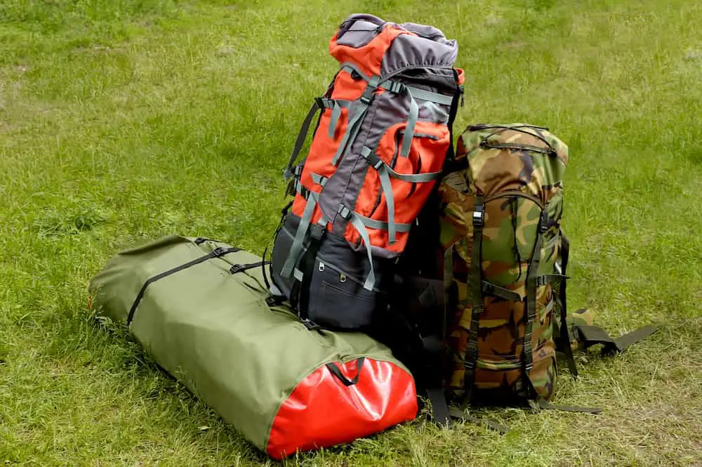 Backpacks sitting on the grass ready for the hike to start again - What Are the Backpacking Big Four