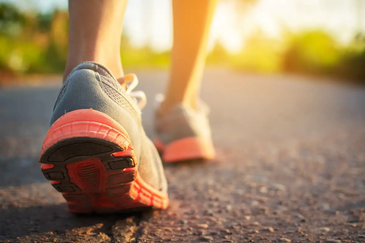 Photo of a lady walking on the road close up of the feet on the pavement.